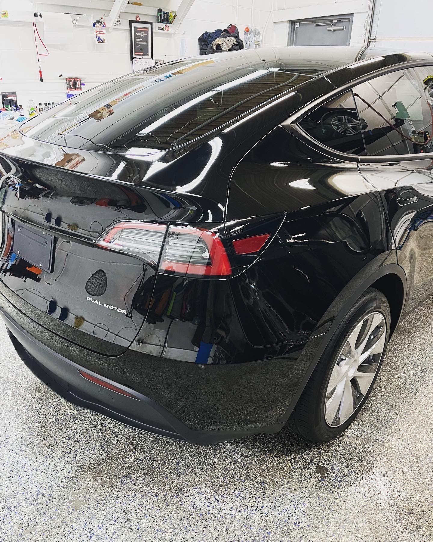 A black tesla model s is parked in a garage.