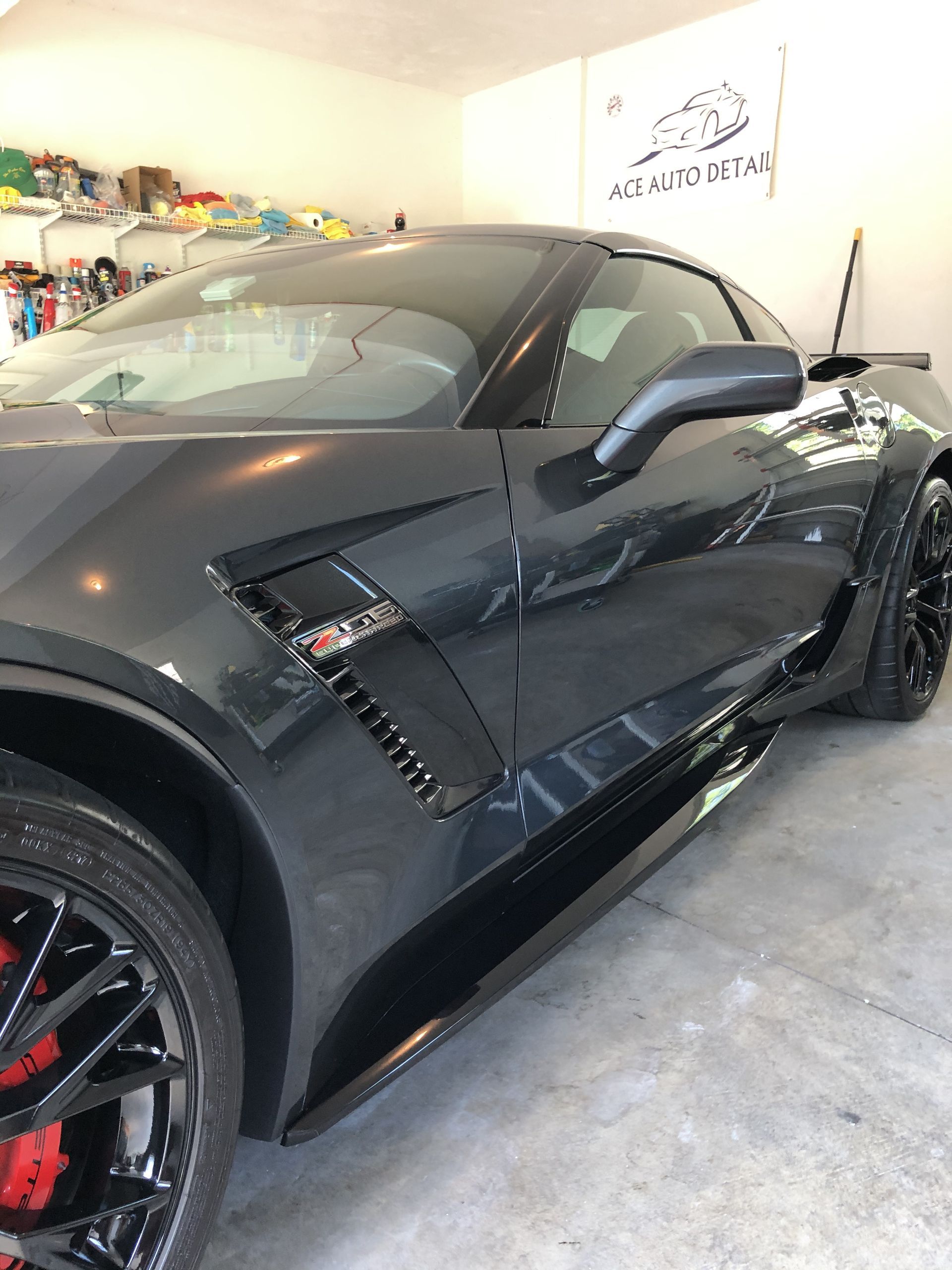 A black sports car is parked in a garage.