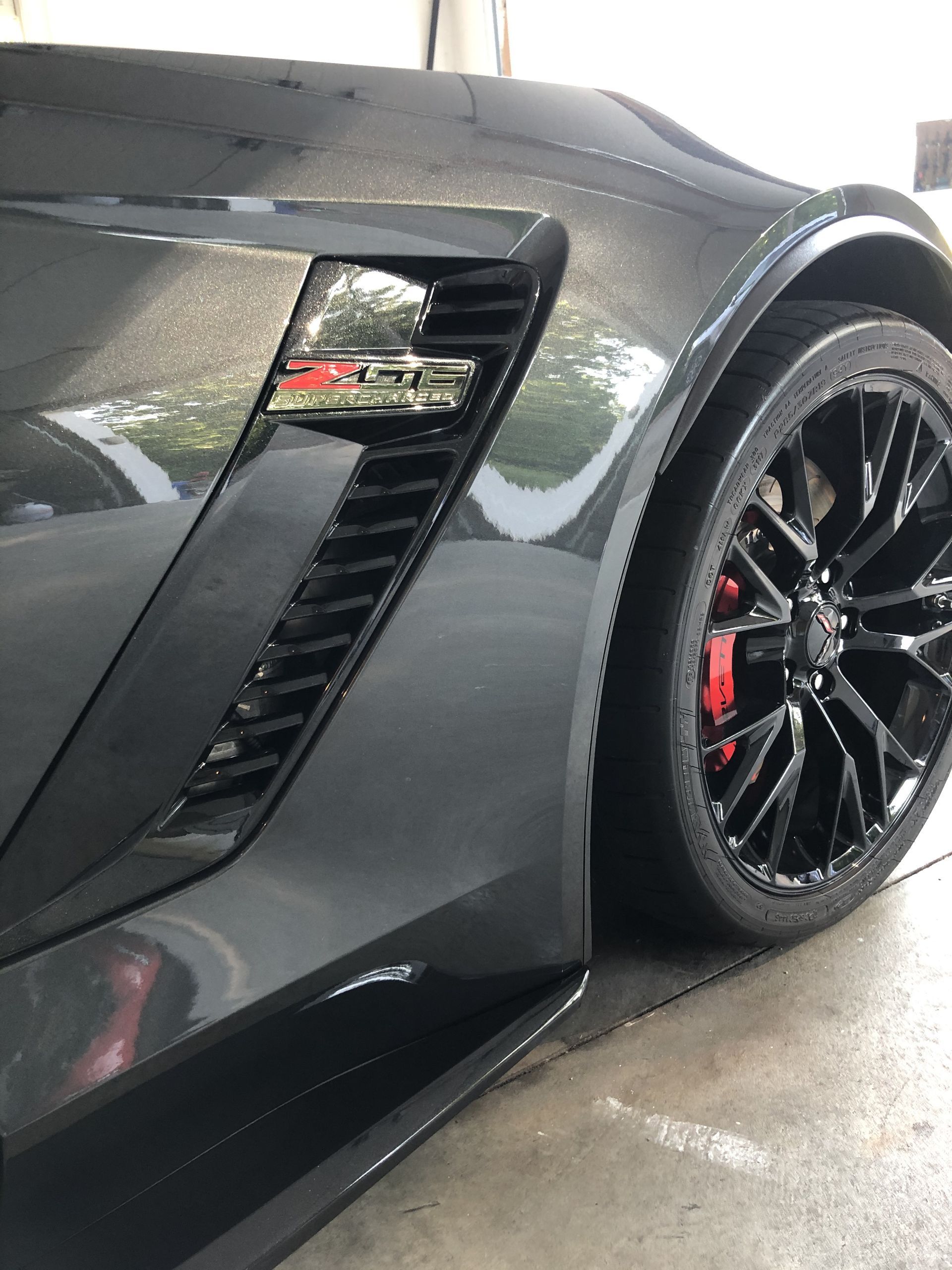 A black sports car is parked in a garage.