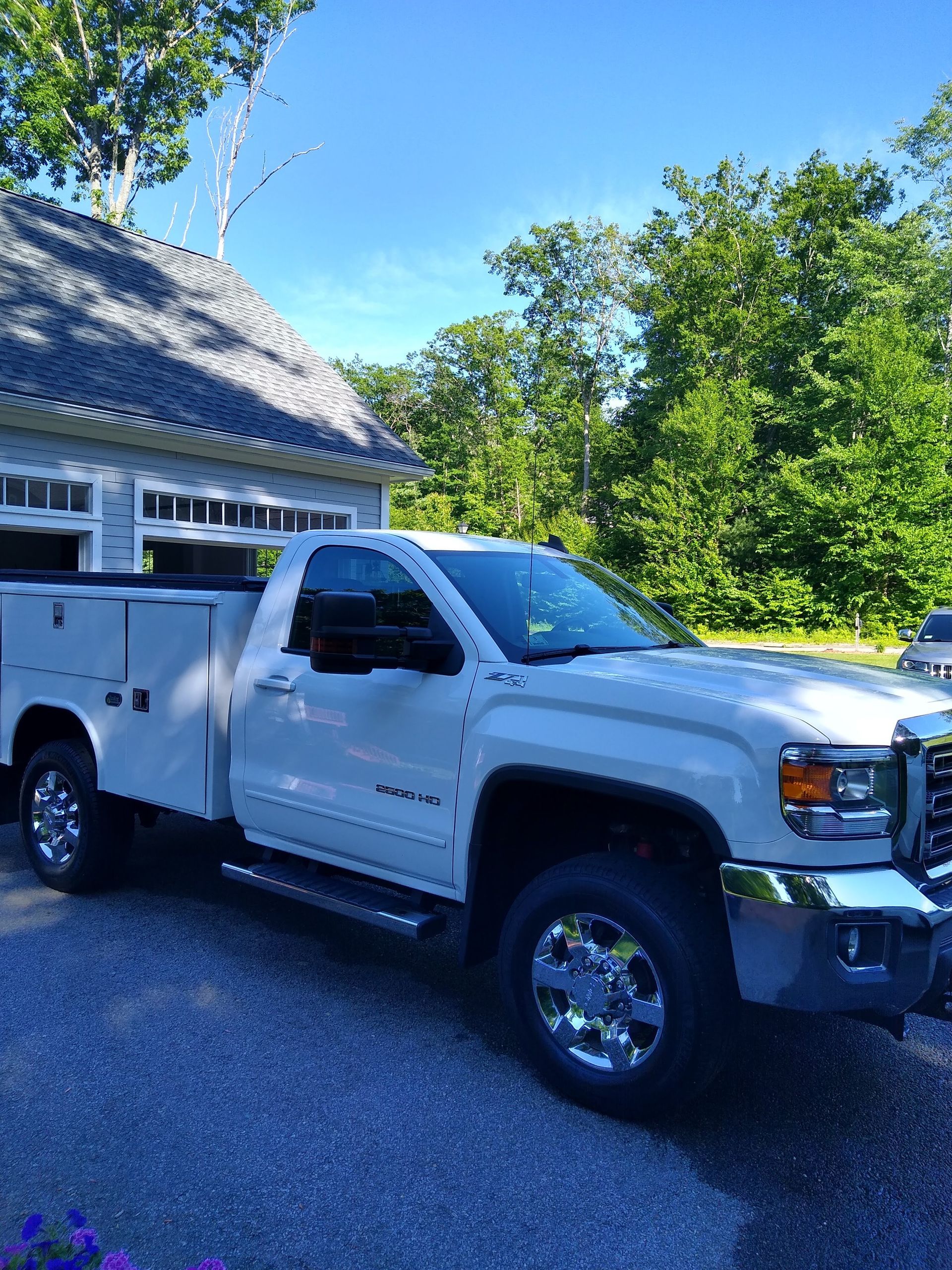 A white truck is parked in front of a garage.