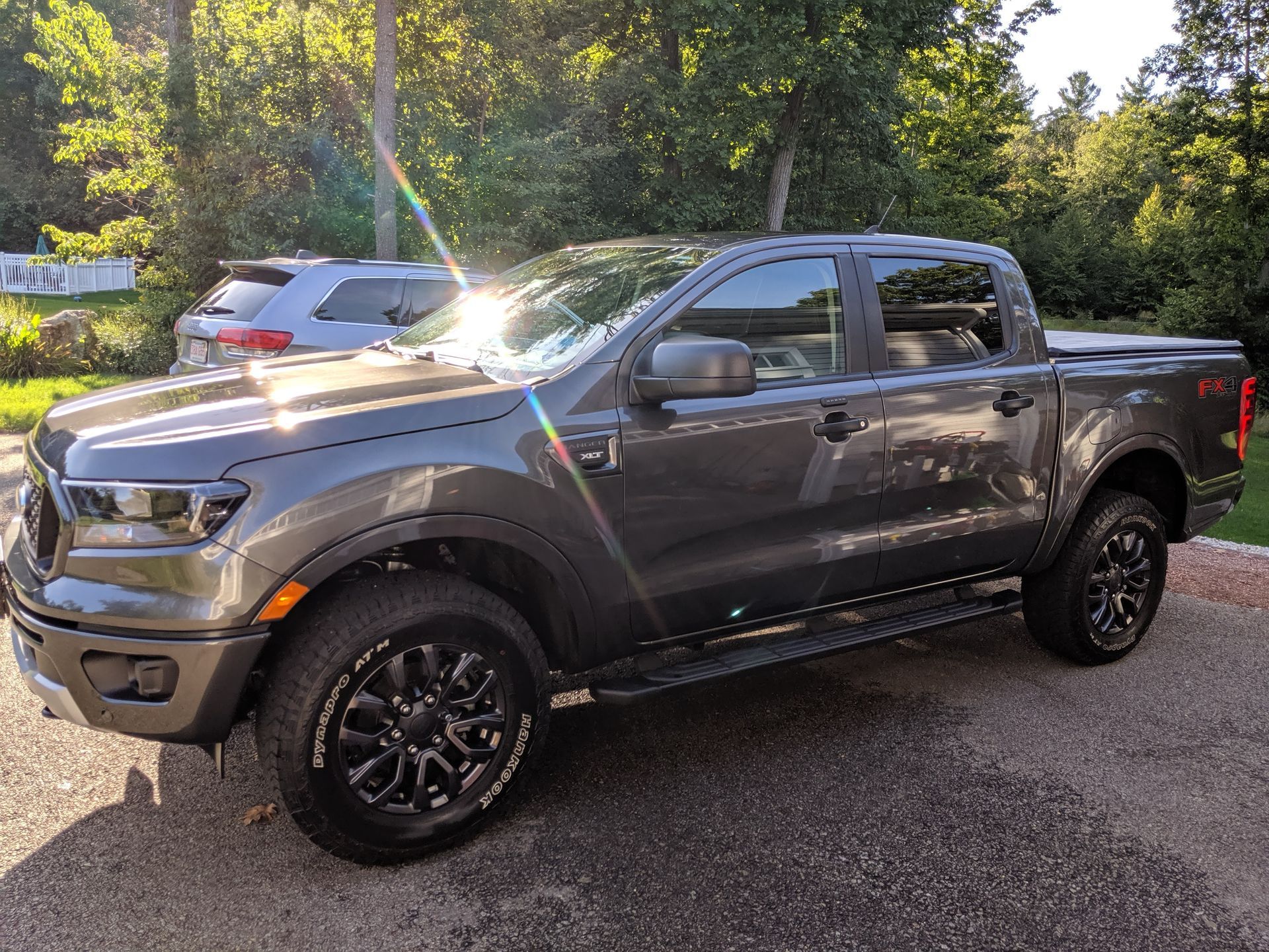 A gray ford ranger truck is parked in a driveway.