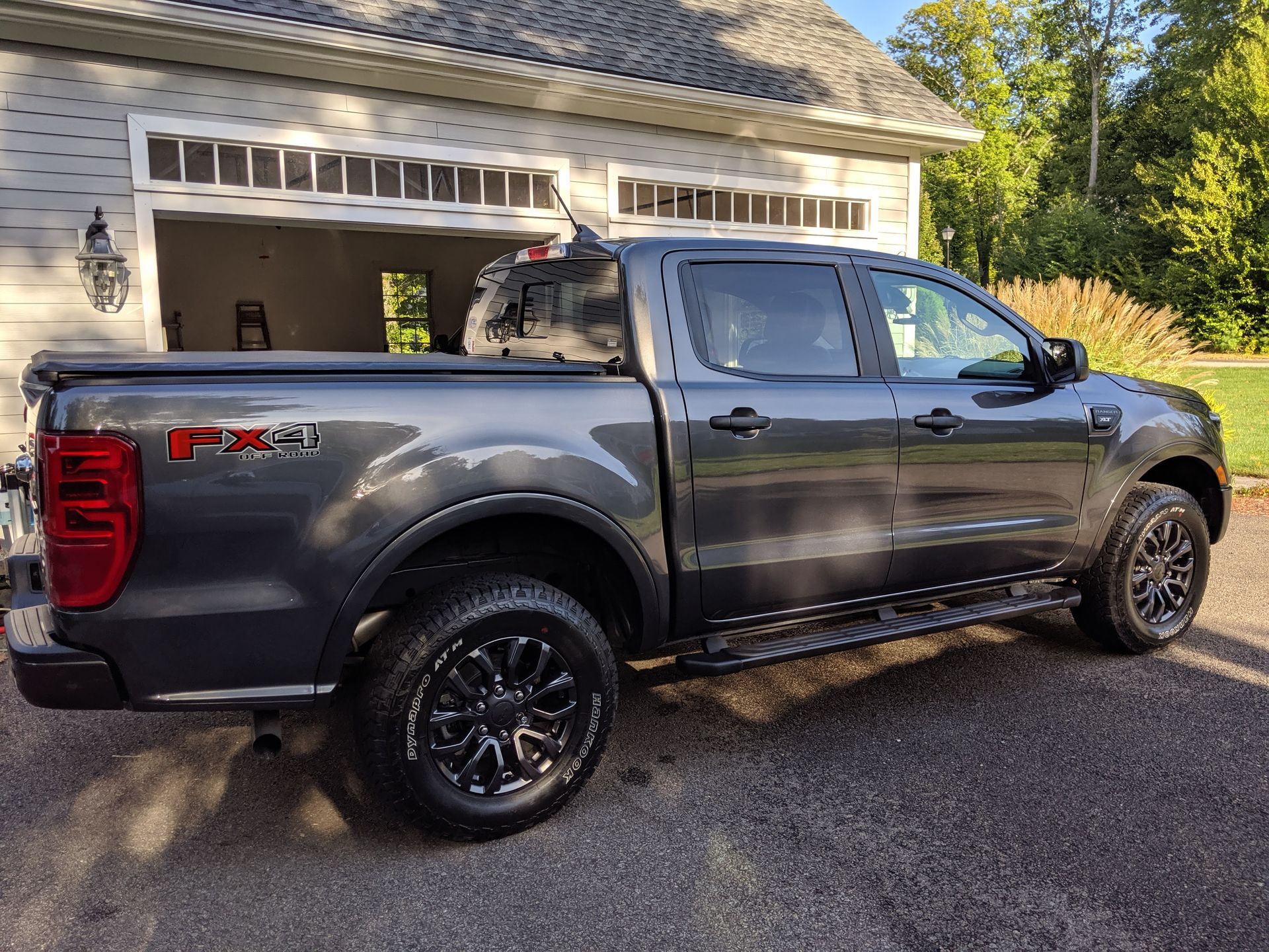 A ford ranger truck is parked in front of a garage.