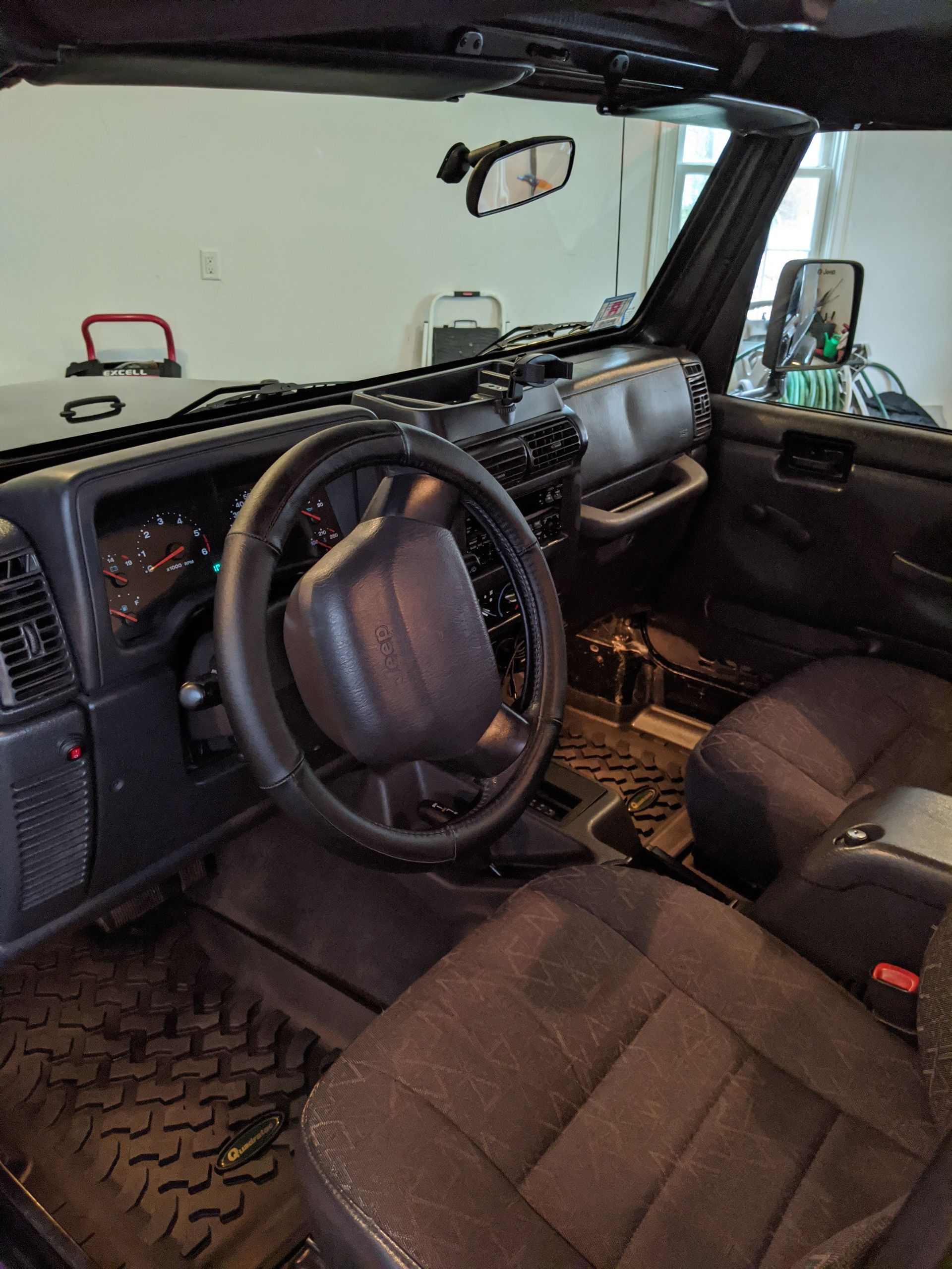 The interior of a jeep wrangler with a steering wheel and seats.