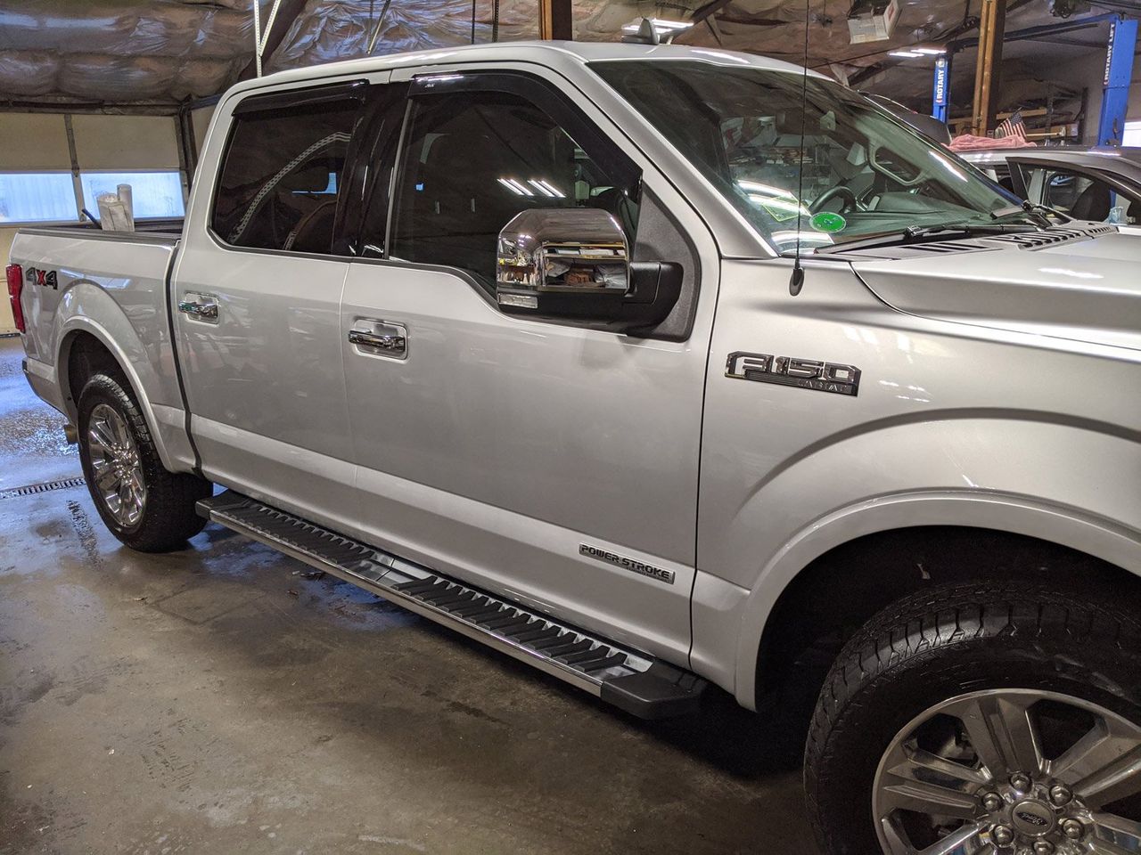 A silver pickup truck is parked in a garage.