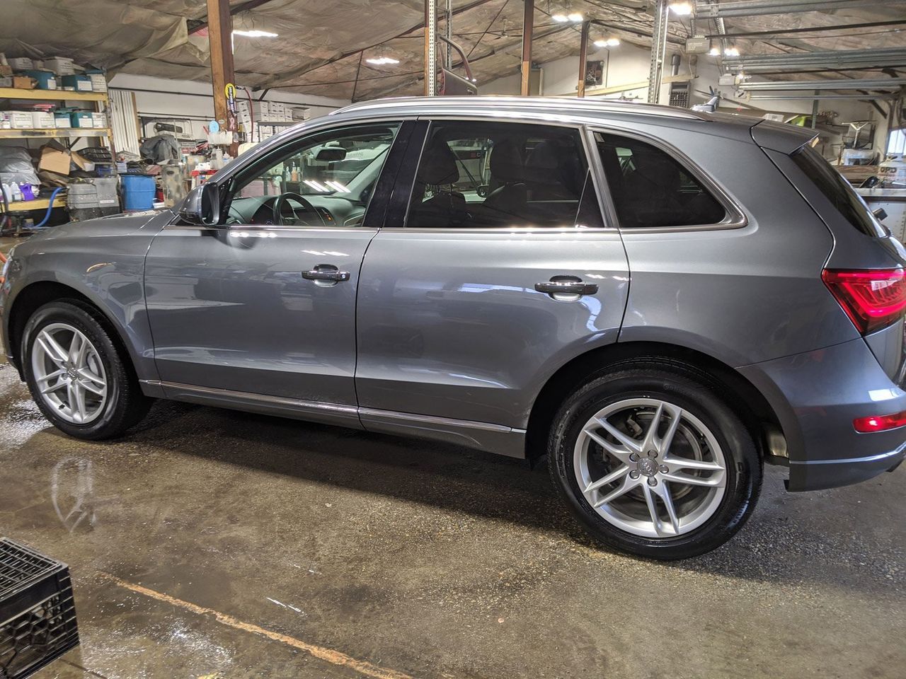 A gray suv is parked in a garage.