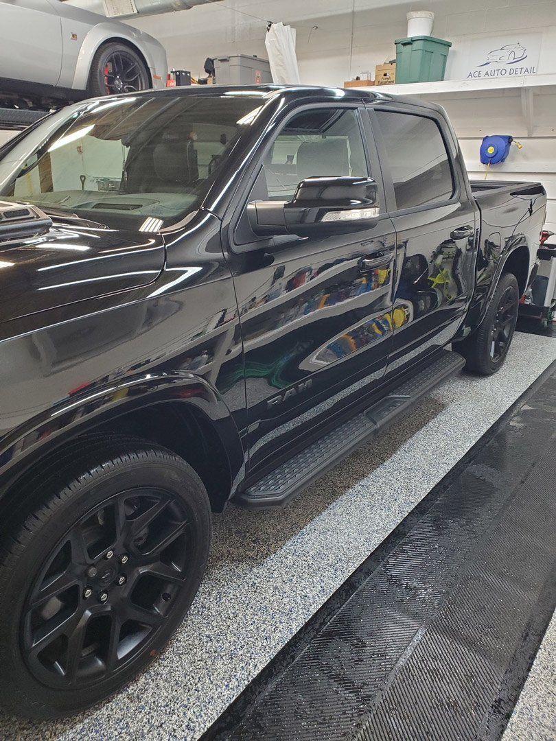 A black pickup truck is parked in a garage.