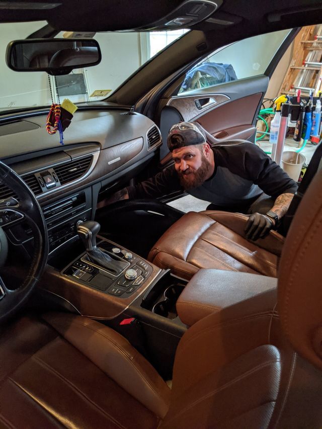 A man is sitting in the driver 's seat of a car.