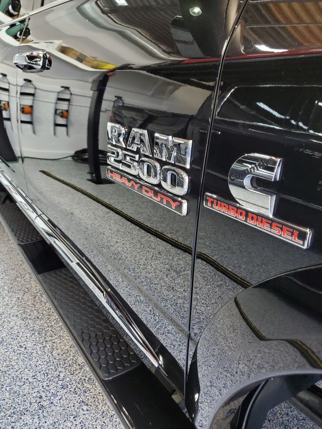A black ram 2500 truck is parked in a garage