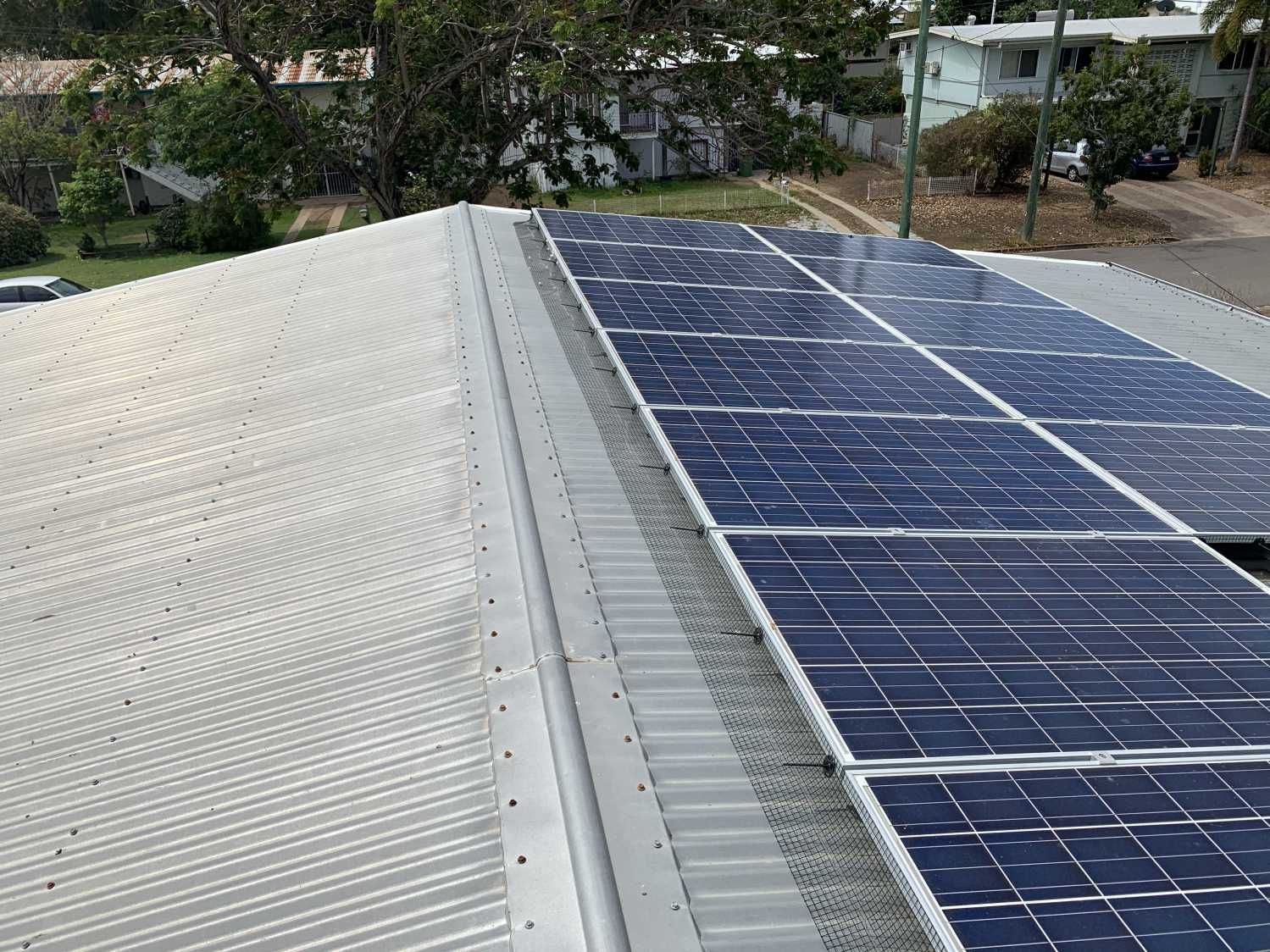 A row of solar panels on the roof of a building.