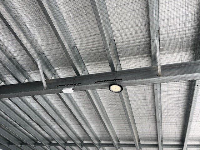 A close up of the ceiling of a building under construction with anti bird proofing.