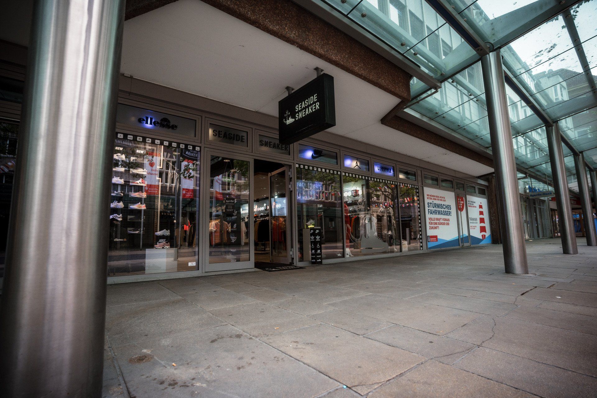 Eine Ladenfront mit Glasdach und einem Schild mit der Aufschrift „Reebok“ darauf.