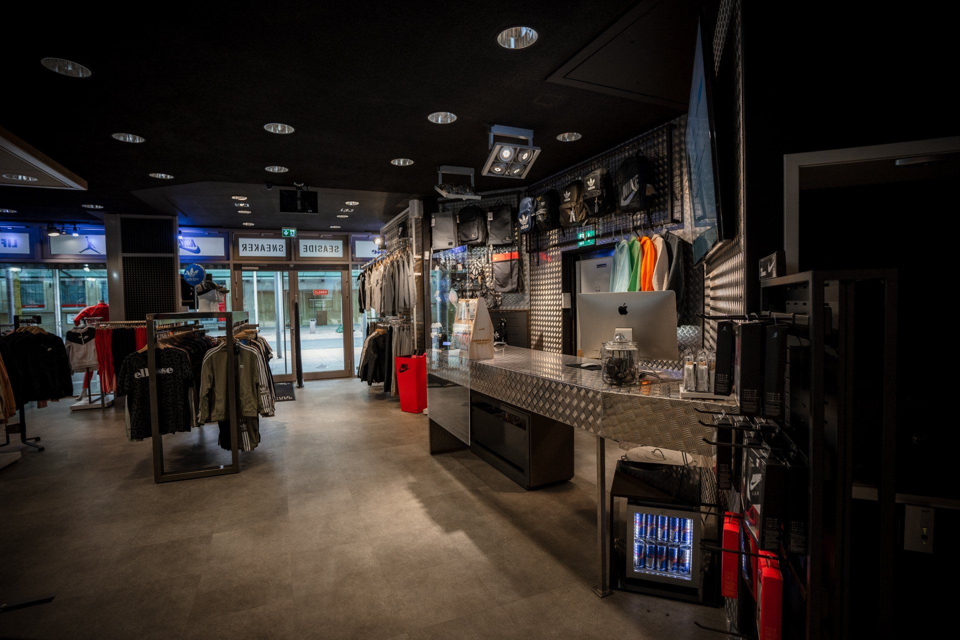 Ein Laden voller Kleidung und ein Schreibtisch mit einem Computer darauf.