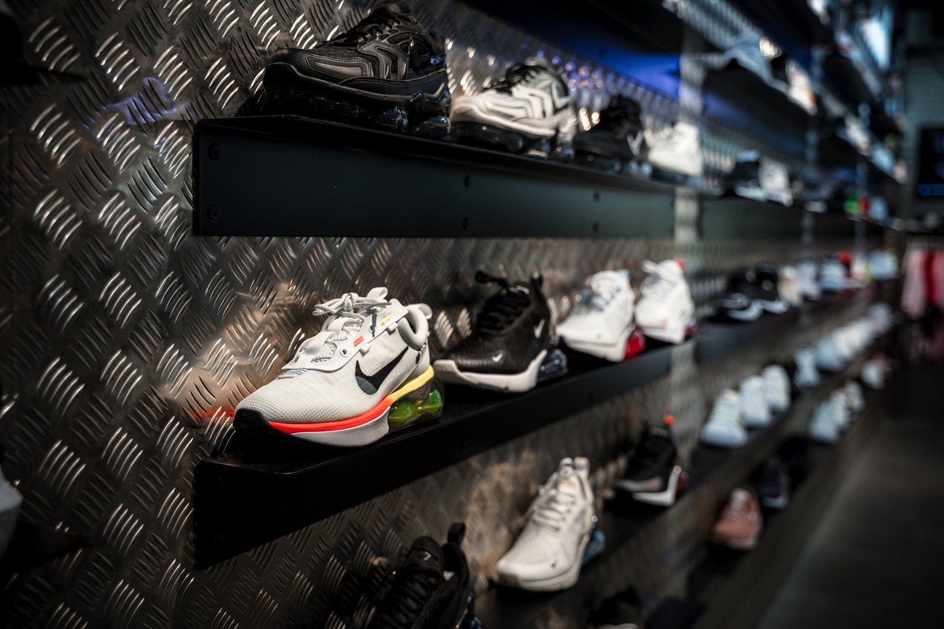 Ein Regal in einem Geschäft, das mit vielen verschiedenen Schuhtypen gefüllt ist.