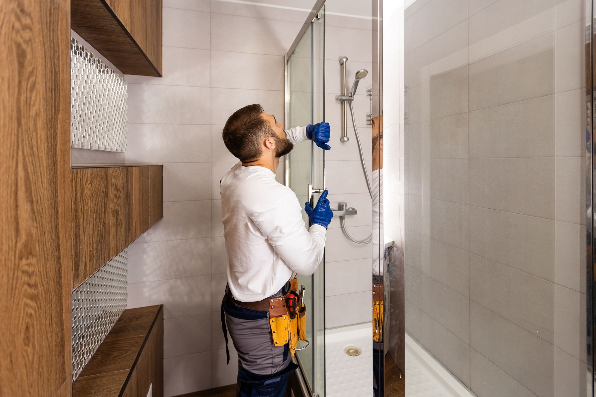 worker connecting glass walls shower enclosure
