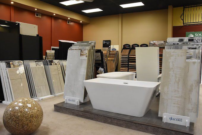 A showroom displaying tiles and a white bathtub on a raised platform.