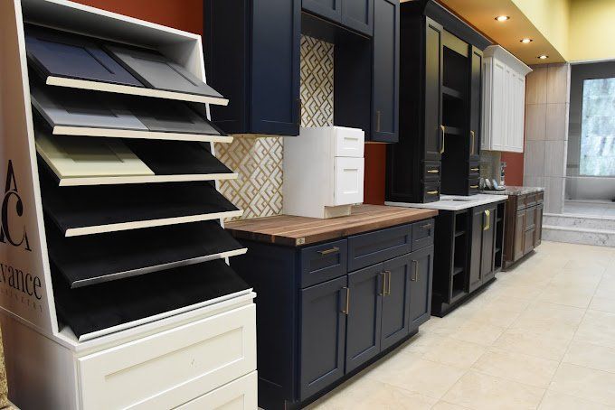 Kitchen cabinet display with various color samples and installed cabinets in a showroom setting.