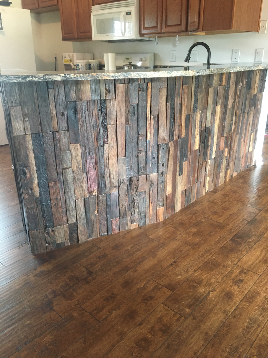 Kitchen island with reclaimed wood facade and granite countertop.