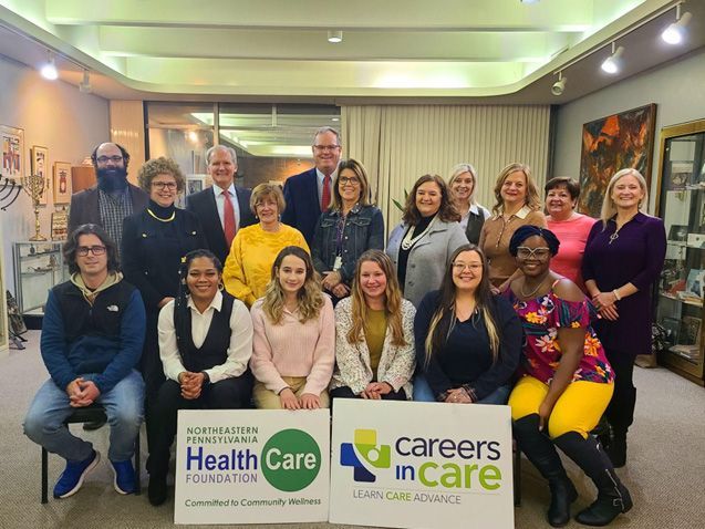 A group of people posing for a picture with a sign that says careers in care