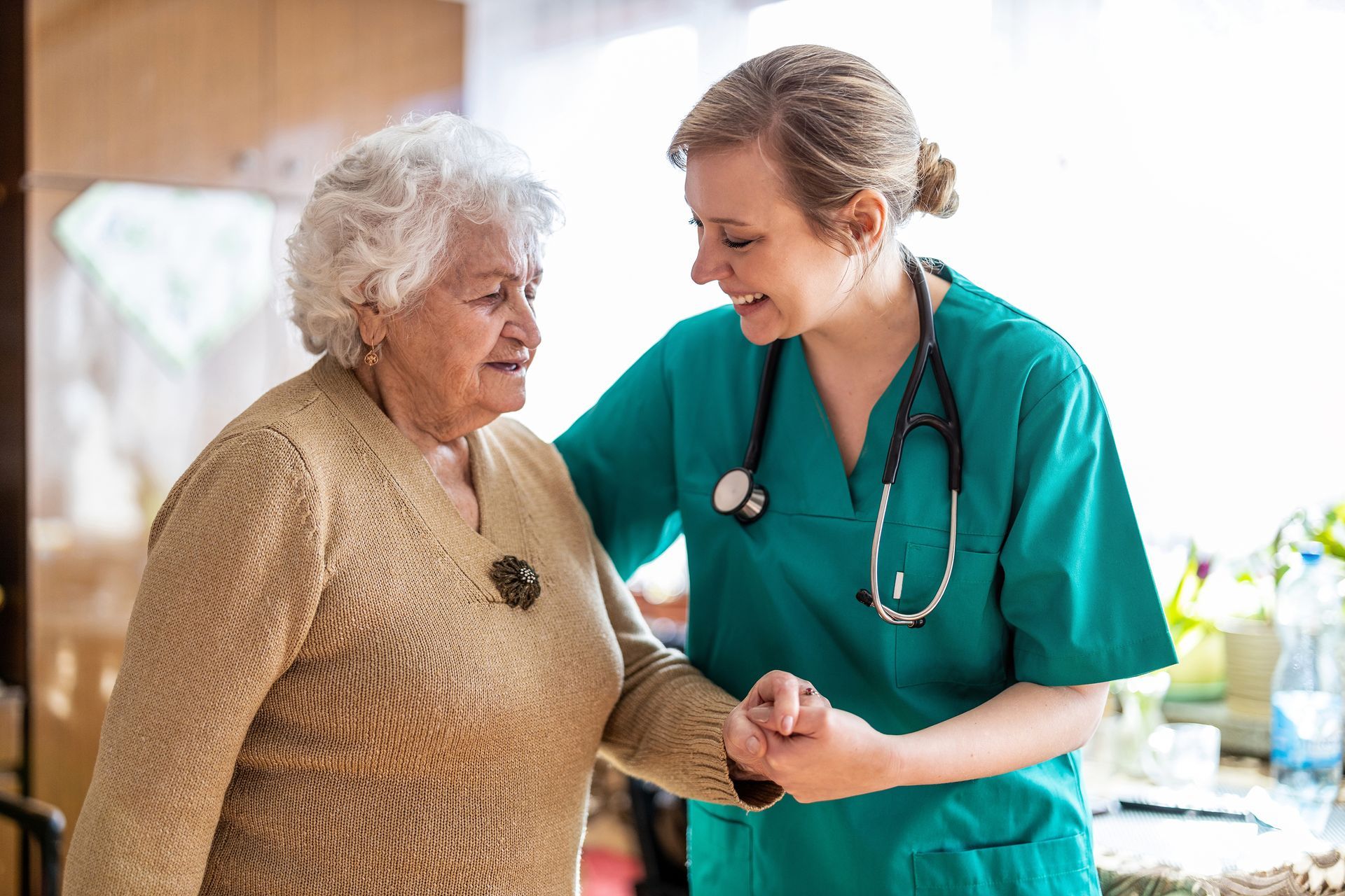 A nurse is helping an elderly woman walk.