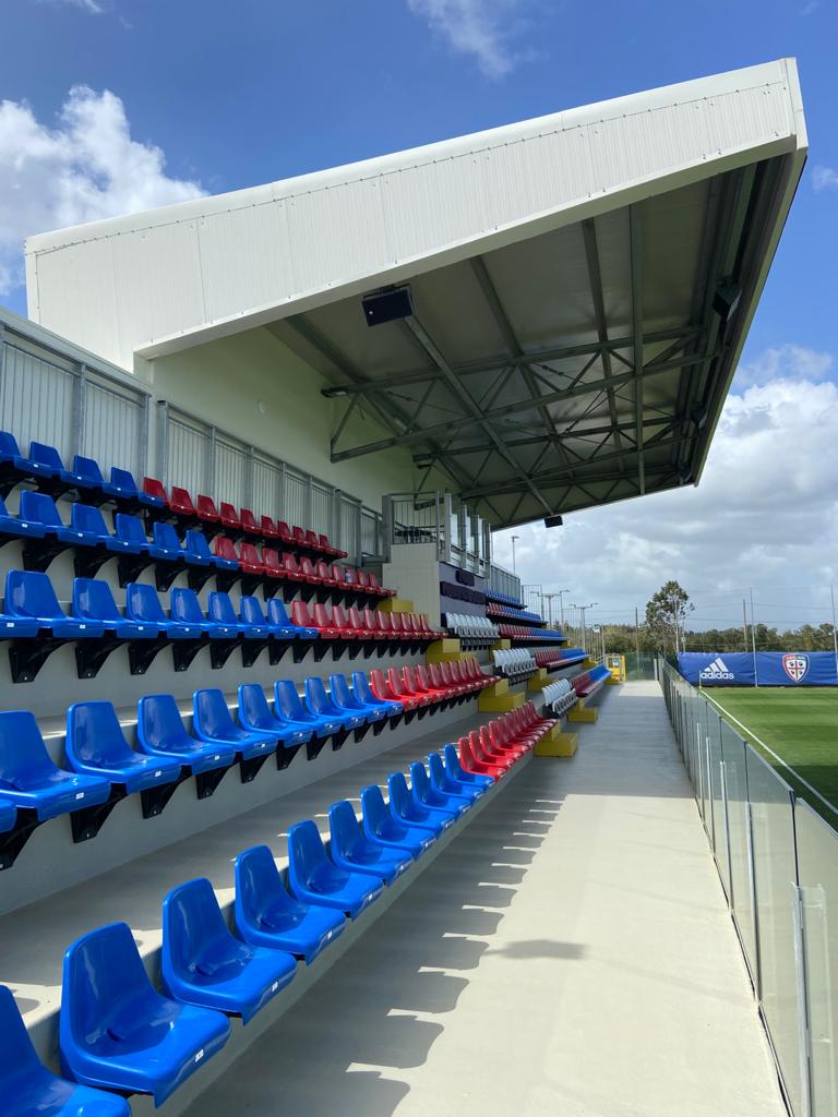 File di sedili blu e rossi in uno stadio