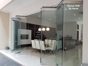 Una sala da pranzo con tavolo e sedie dietro una parete di vetro.