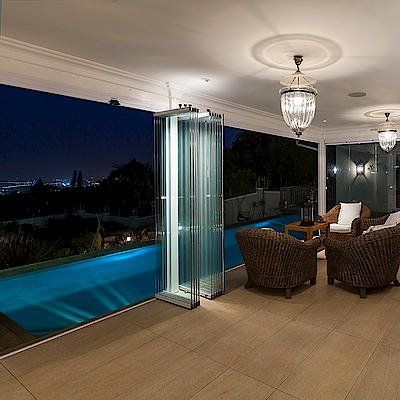 Un soggiorno con sedie e una piscina notturna.