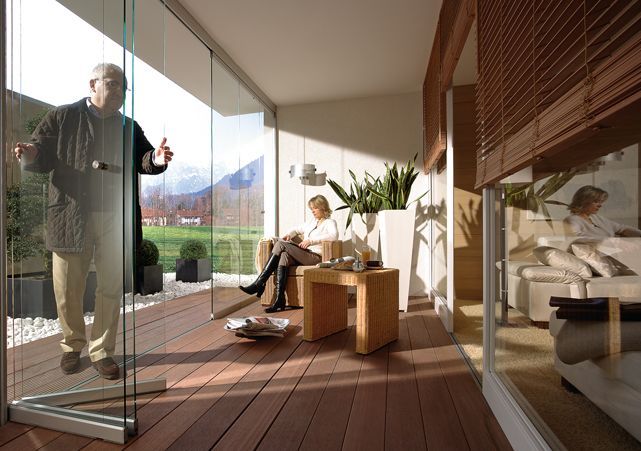 Un uomo e una donna sono seduti su un balcone con porte scorrevoli in vetro.