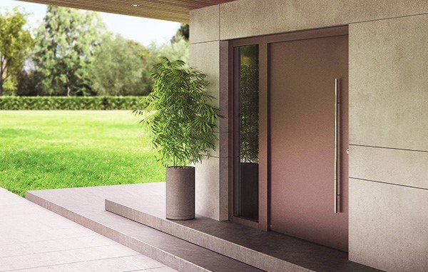 Una porta d'ingresso di una casa con una pianta in vaso davanti ad essa.