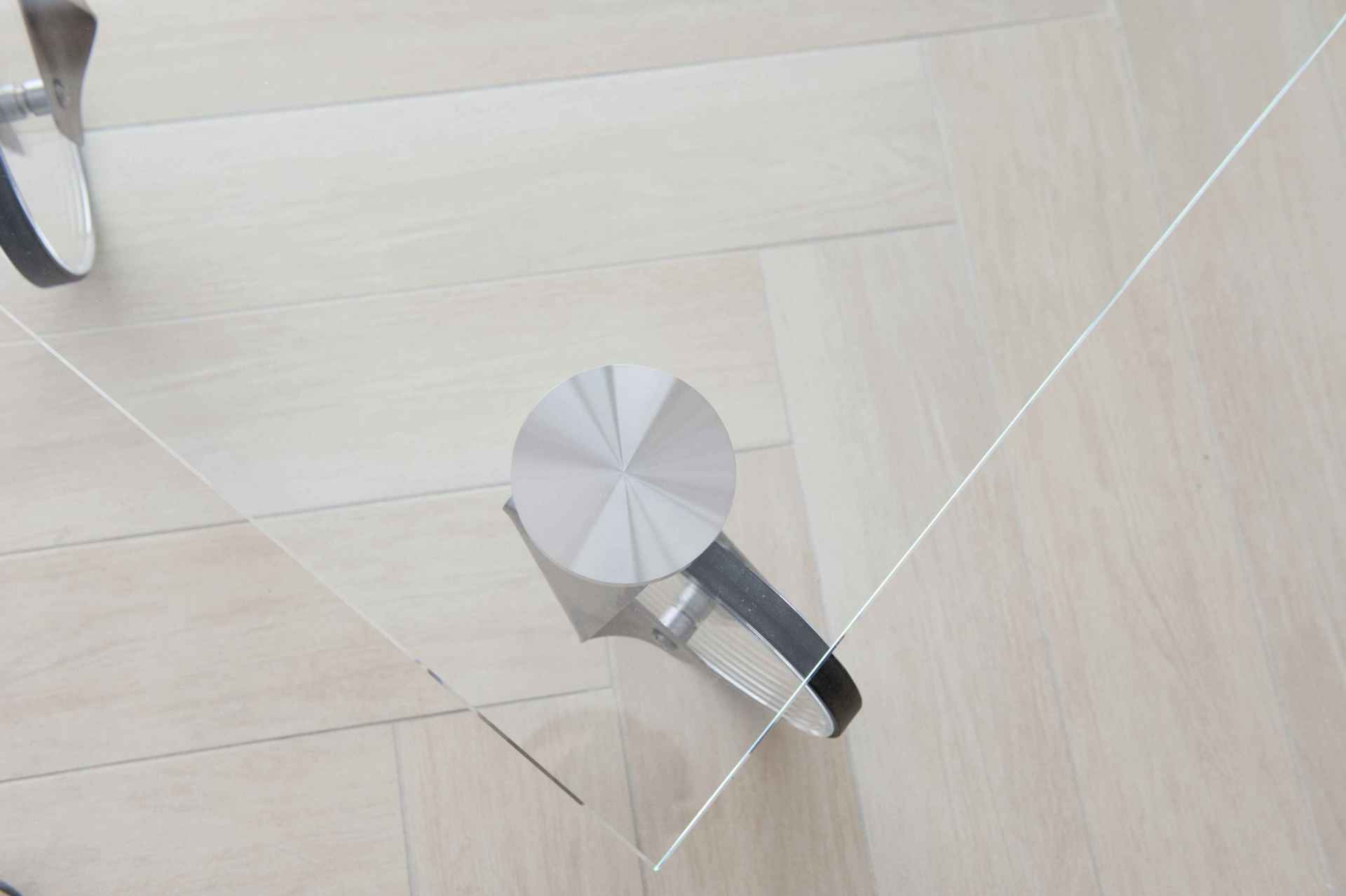 Una caffettiera è seduta su un tavolo di vetro su un pavimento di legno.