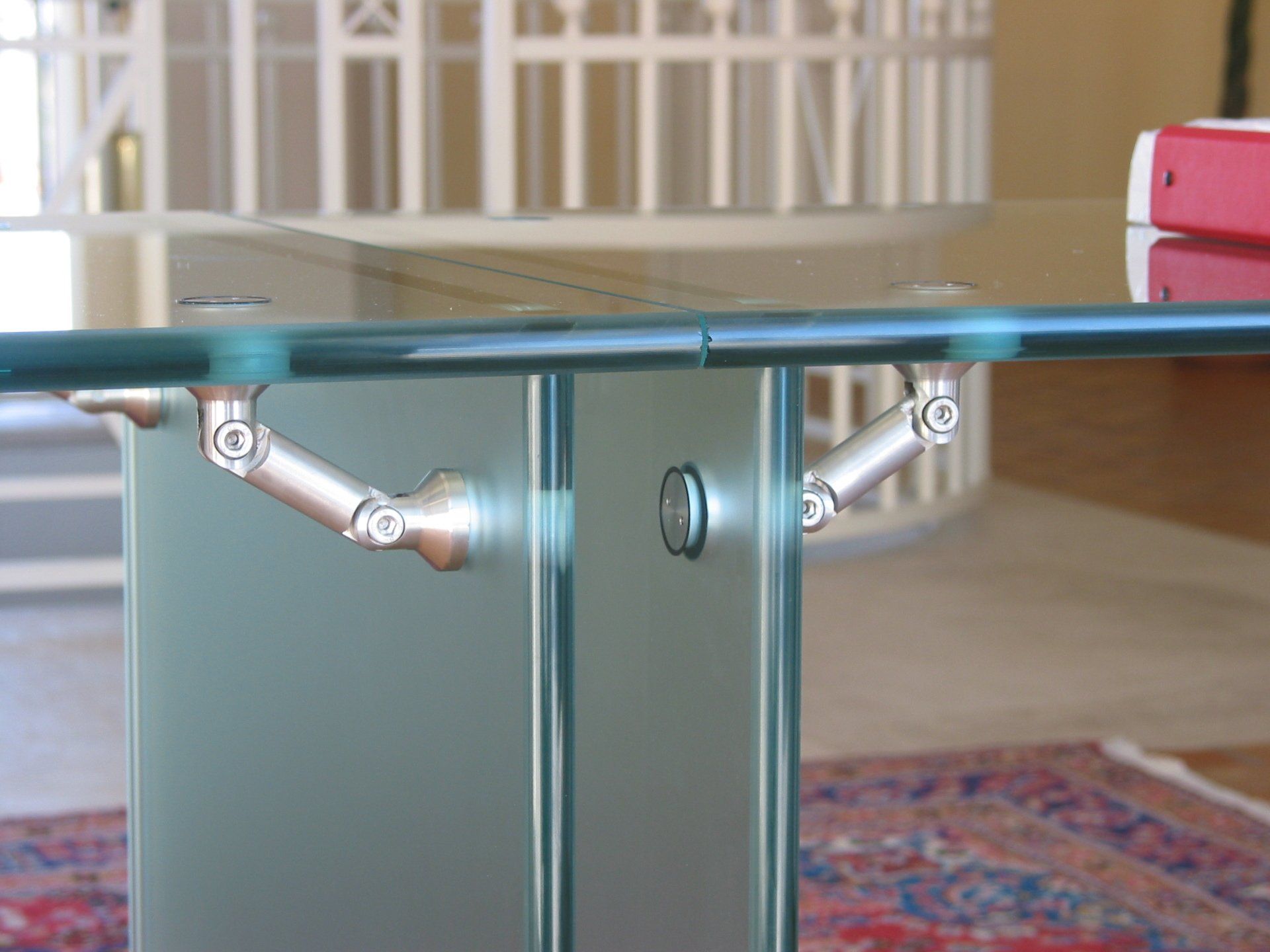 In soggiorno c'è un tavolo di vetro con base in metallo.