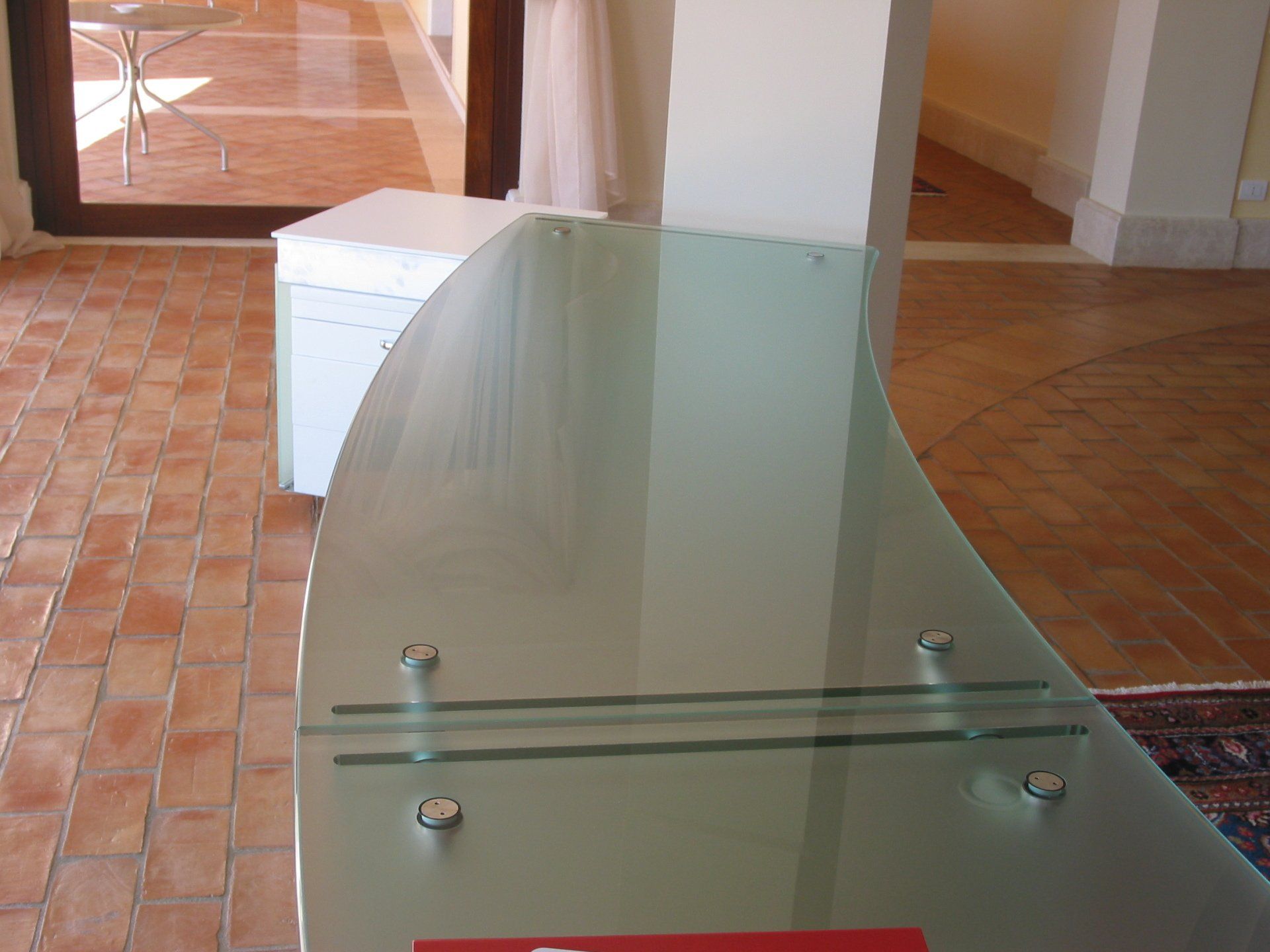 Un soggiorno con divano, sedie e una piscina di notte.