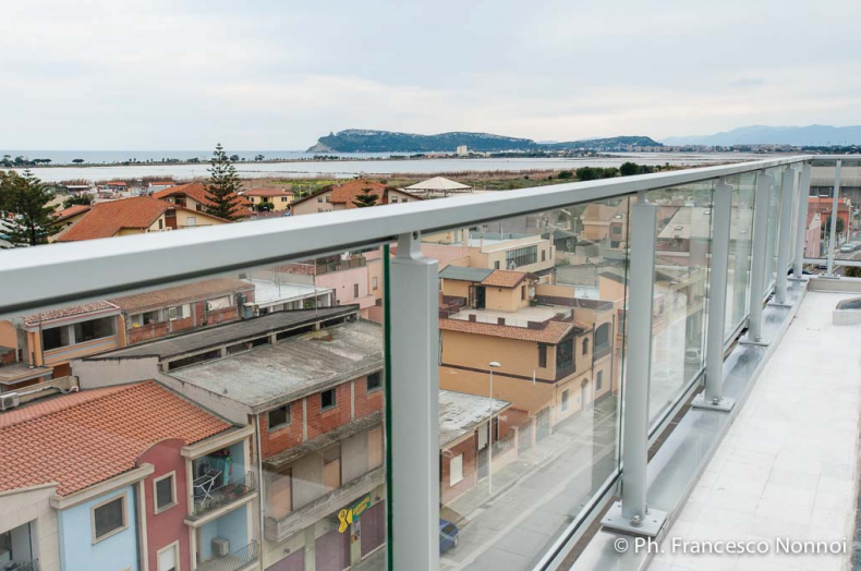 Una vista di una città da un balcone con ringhiera in vetro