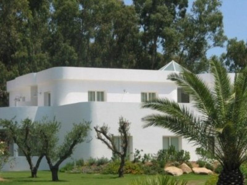 Una casa bianca con una palma davanti