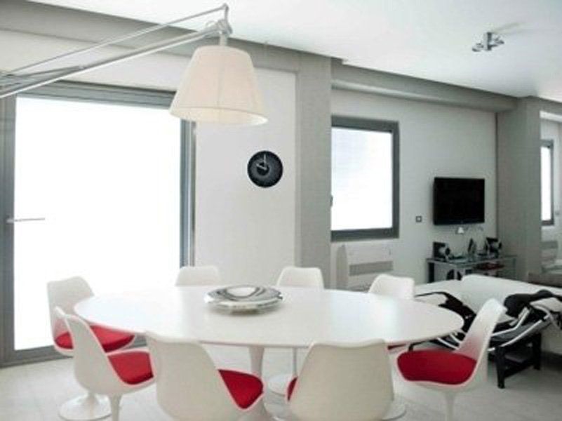 Una sala da pranzo con tavolo rotondo e sedie rosse