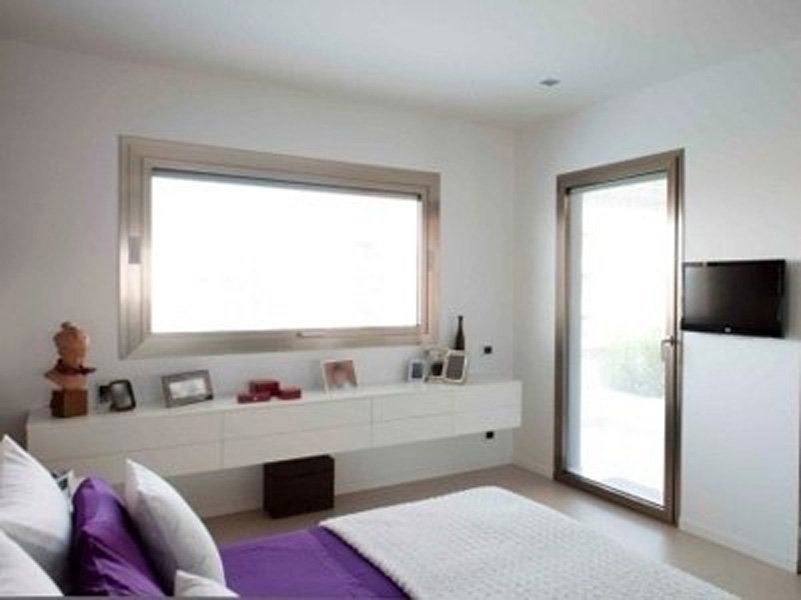 Una camera da letto con un letto viola e una grande finestra