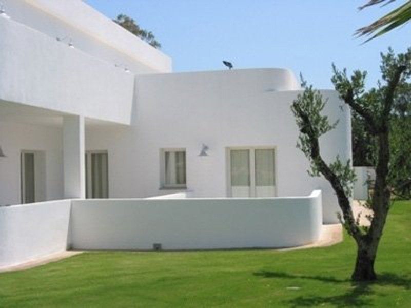 Una casa bianca con un albero davanti