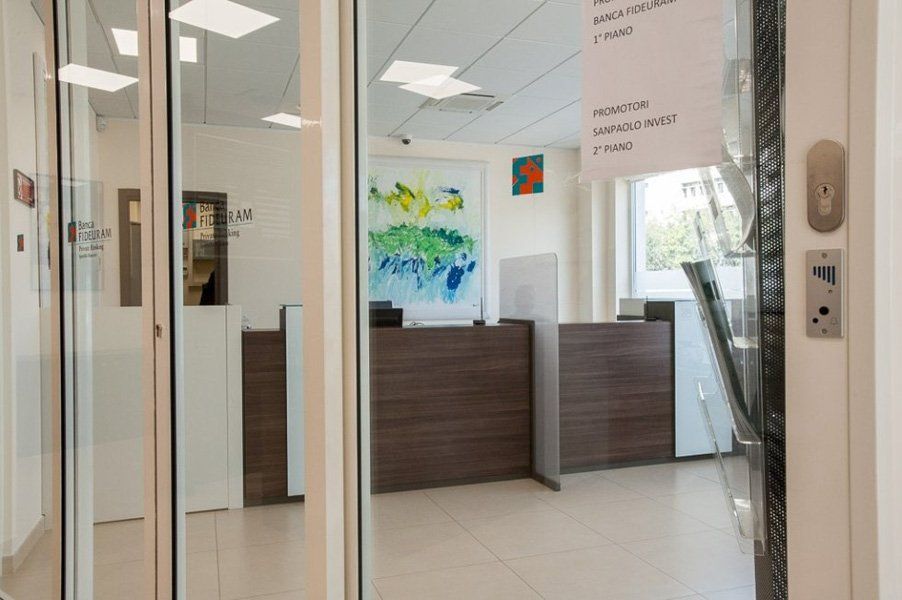 Un atrio con porta a vetri e bancone in legno.