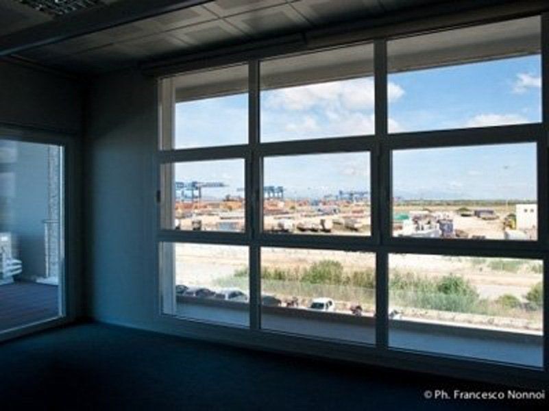 Una stanza con molte finestre e vista su una città