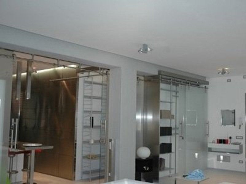 Una stanza con porte scorrevoli in vetro e un lavandino