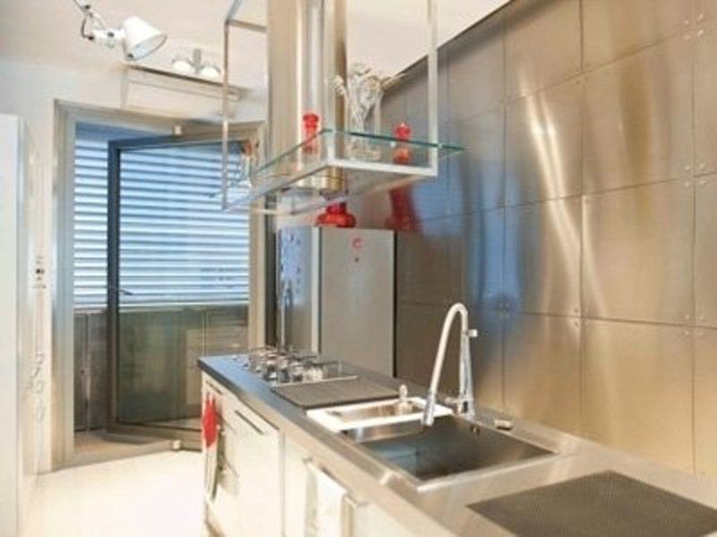 Una cucina con elettrodomestici in acciaio inox e lavello