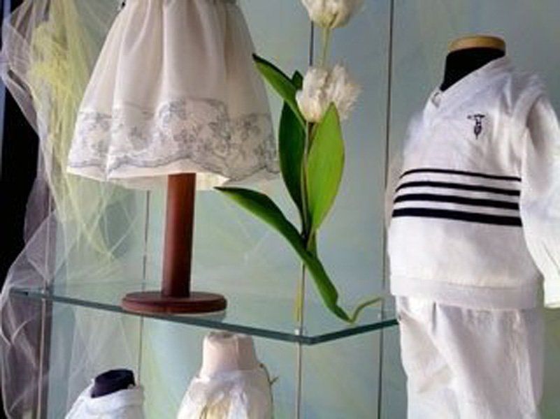 Un'esposizione di vestiti per bambini su un ripiano di vetro