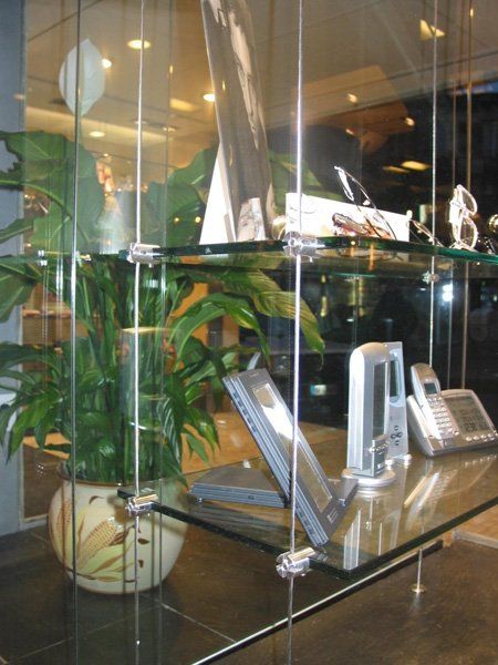 Una mensola di vetro con sopra una pianta e un telefono