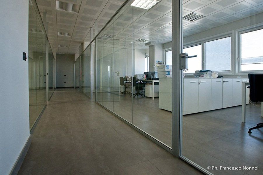 Un corridoio con una parete di vetro tra due uffici