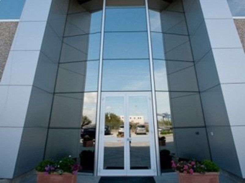 Un grande edificio con il riflesso del cielo nelle finestre