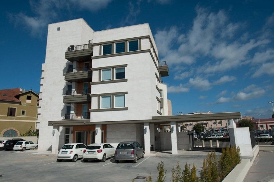 Un edificio bianco con delle macchine parcheggiate davanti