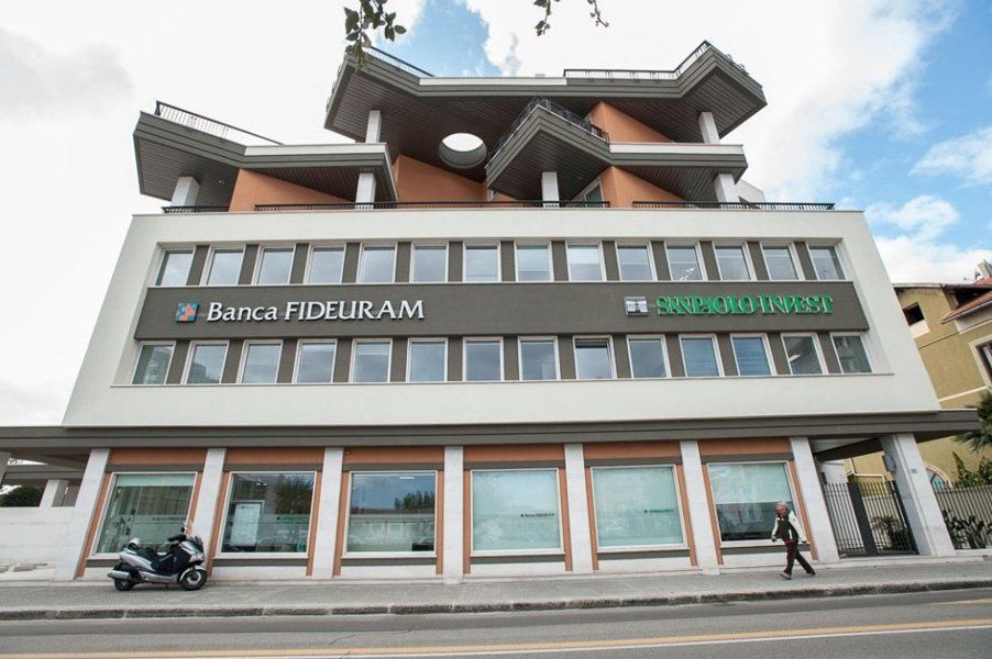 Un grande edificio con una moto parcheggiata di fronte.