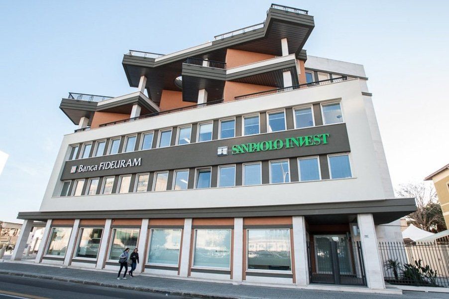 Un grande edificio con tante finestre e un cartello verde con scritto 'snm' sopra