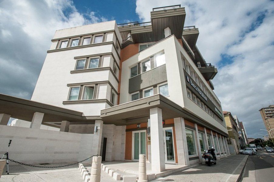 Un grande edificio con tante finestre e uno scooter parcheggiato davanti