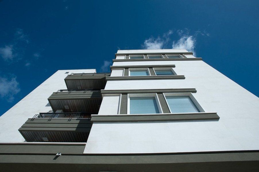 Guardando un edificio bianco con balconi contro un cielo blu