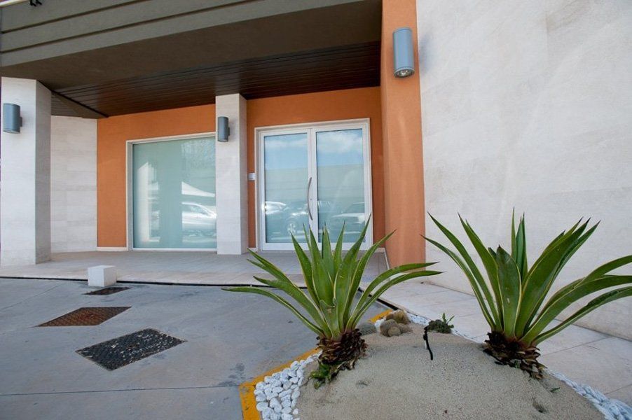 Un edificio con molte finestre e piante davanti